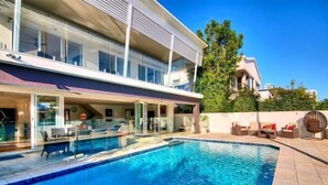 A modern two-story building with a swimming pool, outdoor seating, and a view of a neighboring building. - Surfers Paradise Escape (Heated Pool) (Surfers Paradise)