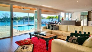 A modern living room with a large glass door leading to a pool area. - Surfers Paradise Escape (Heated Pool) (Surfers Paradise)
