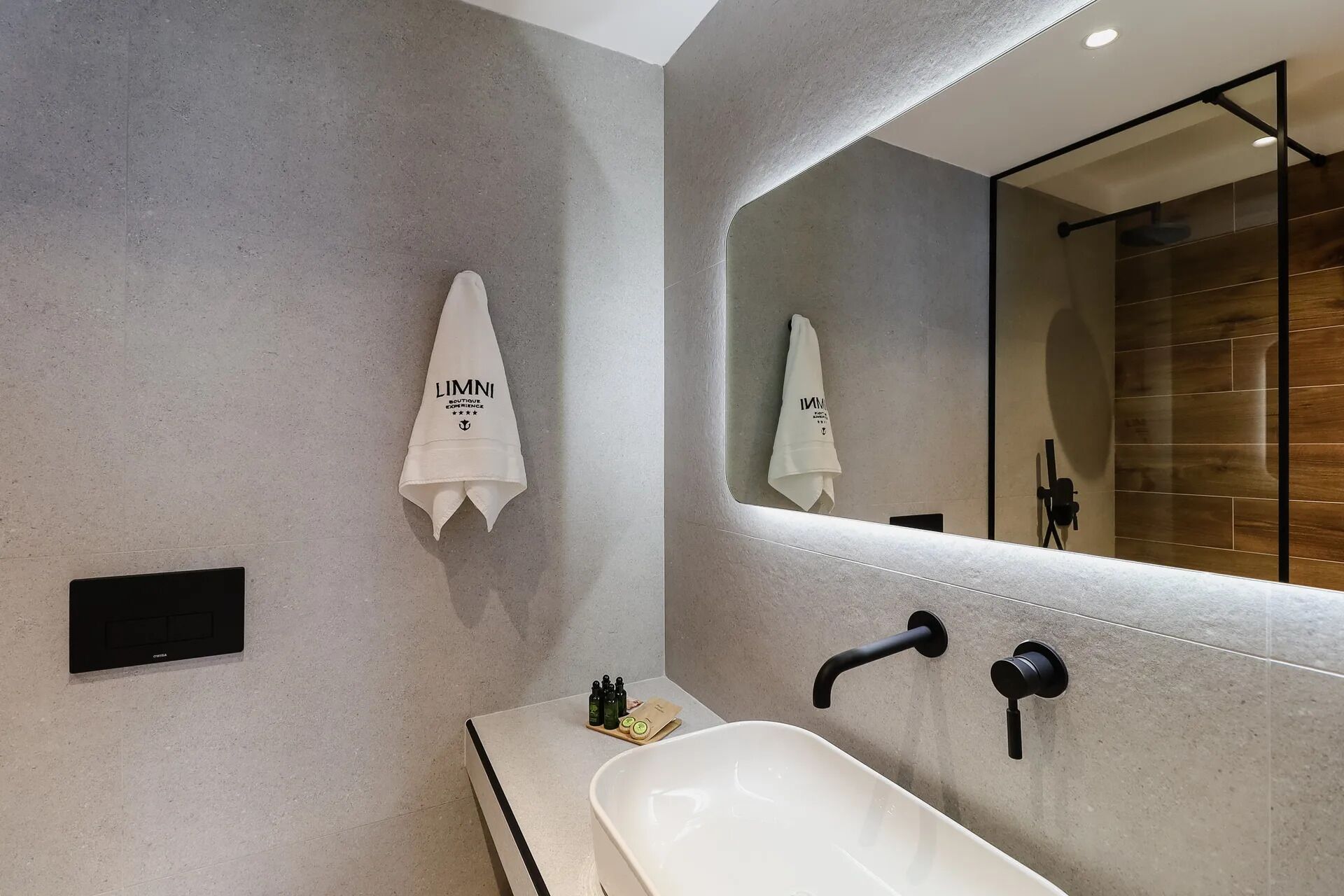 A modern bathroom with a large mirror, a white sink, and two towel dispensers.
