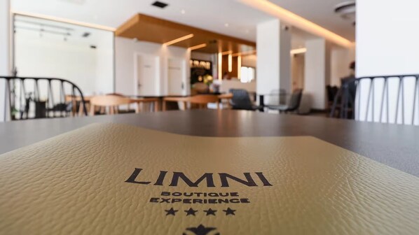 A table with a napkin that reads "LIMNI BOUTIQUE EXPERIENCE" and has four stars.