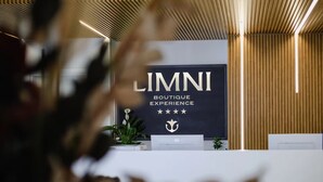 Ein Empfangstresen mit einem Schild, auf dem 'LIMNI BOUTIQUE EXPERIENCE' steht, und einem Logo.