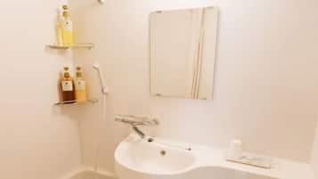 A bathroom with a bathtub, a sink, and a toilet. There are shelves with toiletries and a mirror above the sink.