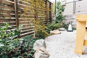 A garden with a wooden fence, a gravel path, and a lantern. - Kyoto KaedeHotel Kamogawa (Kyoto)