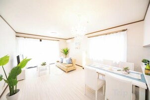 Un salón amplio con sofá, mesa de centro y comedor con mesa y sillas.