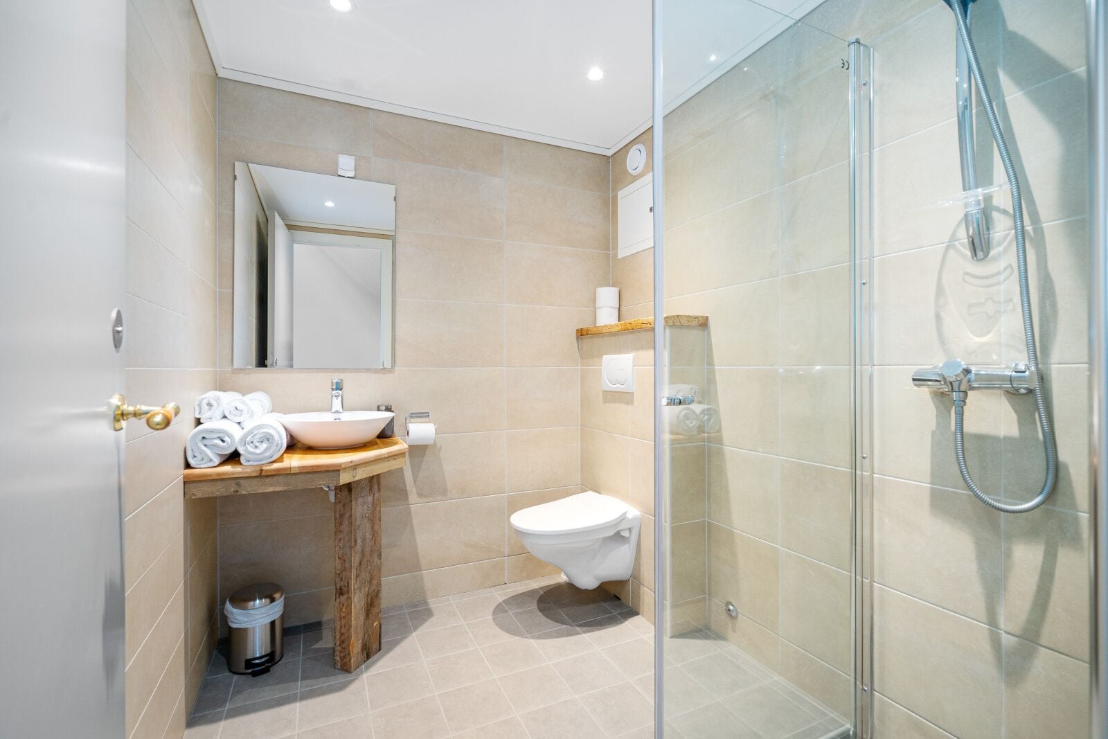 A modern bathroom with a sink, toilet, and glass-enclosed shower.
