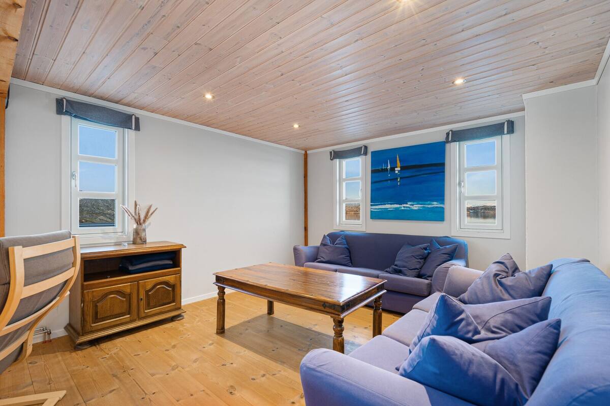 A cozy living room with a wooden ceiling, a sofa, a coffee table, and a cabinet.