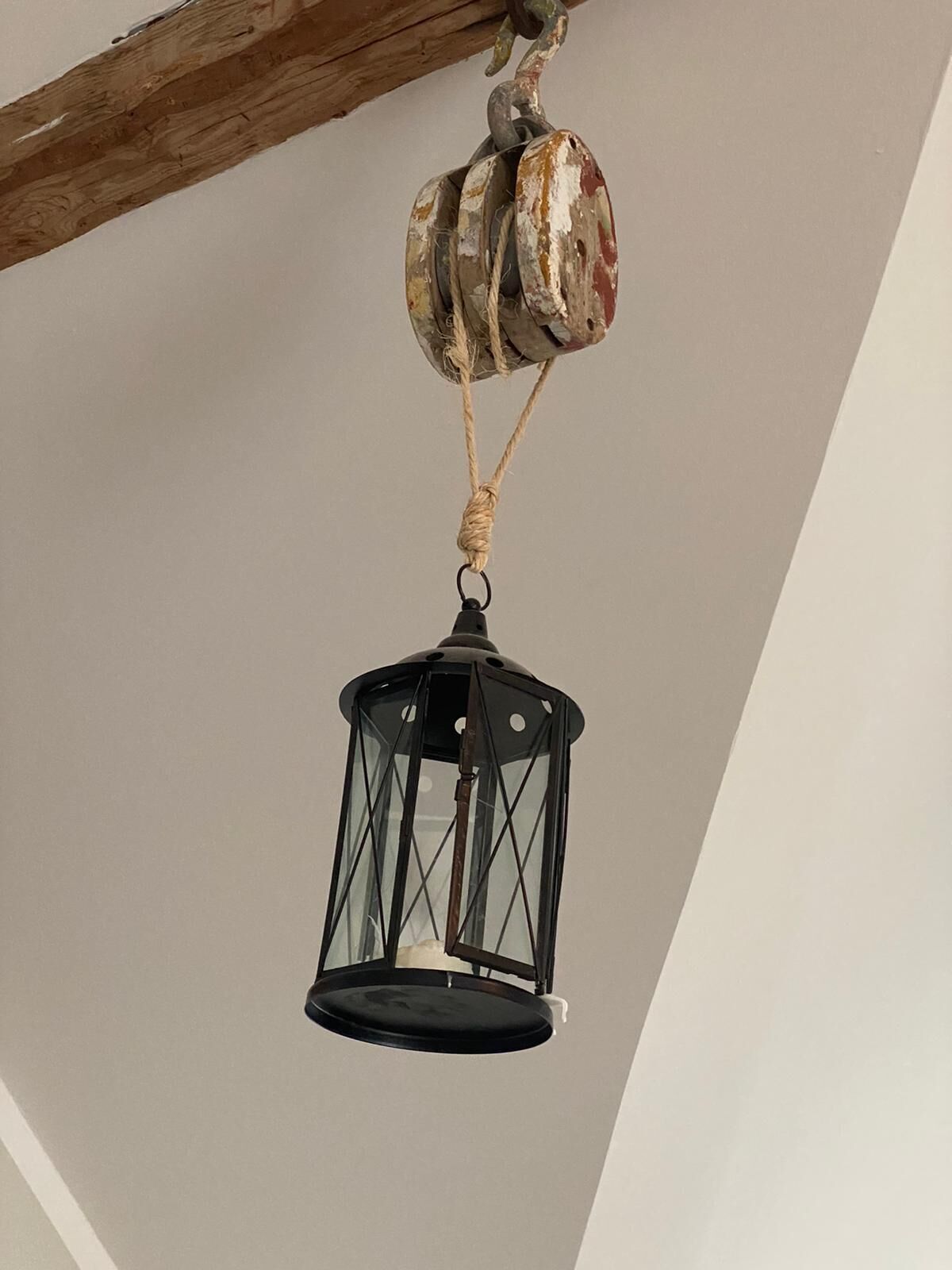 A rustic lantern hanging from a wooden beam.
