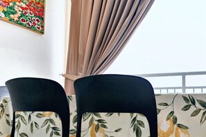 Un balcon avec deux chaises noires et un canapé à motifs floraux.