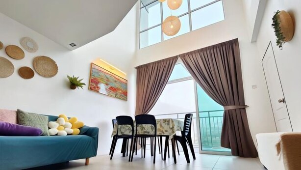 A modern living room with a sofa, dining table, chairs, and a large window with curtains.