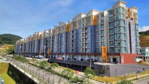 A multi-story hotel with a modern architectural design, featuring a series of balconies and large windows.