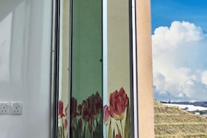 A window with a floral design and a view of a hill with snow. - The Floral Penthouse @ Cameron Highlands (Brinchang)