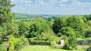 A lush green landscape with a clear sky, a view of distant hills, and a body of water. - Vacation apartment with lake view in Hattingen - an oasis of well-being in the middle of the Pott! (Hattingen)