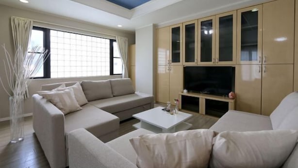 A modern living room with a sofa, coffee table, and TV cabinet. - ELLE Namba Villa (Osaka)