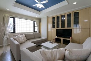 Una sala moderna con un conjunto de sofás, una mesa de centro y armarios empotrados.