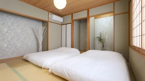 A traditional Japanese room with tatami flooring, a low wooden ceiling, and sliding shoji doors. - ELLE Namba Villa (Osaka)