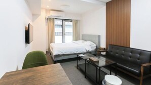 A hotel room with a bed, a sofa, a coffee table, and a TV. - leopard Shinsaibashi (Osaka)