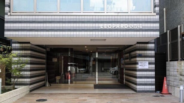 A hotel entrance with a tiled facade and a sign in a foreign language. - leopard Shinsaibashi (Osaka)