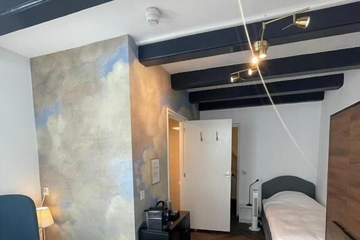 A room with two beds, a desk, a lamp, and a wardrobe.