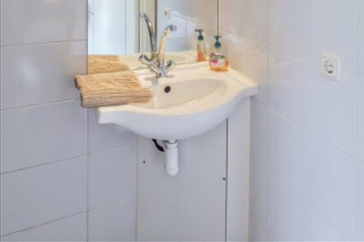 A bathroom with a white sink, a mirror, and a towel rack.
