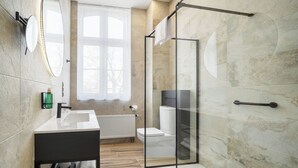 Un baño moderno con cabina de ducha de vidrio, un lavabo blanco y un espejo grande.