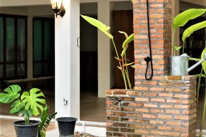 A brick structure with a water feature, potted plants, and a door leading to an interior space. - Phi Private Villa: Luxury 4 beds Riverside & Pool: Near old townBreakfast, Laundry, Free pickup (Chiang Mai)