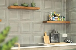 Una cocina con dos repisas de madera, una tabla de cortar, cuchillos y una tableta sobre el mostrador.