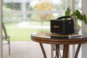 A black Marshall speaker on a glass table with a plant in the background. - Phi Private Villa: Luxury 4 beds Riverside & Pool: Near old townBreakfast, Laundry, Free pickup (Chiang Mai)
