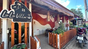 Un restaurant appelé « La Villa Koh Larn », doté d’un toit de chaume et d’une clôture en bois.
