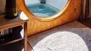 Un miroir rond avec un cadre en bois, une lampe et une vue sur une piscine et un bâtiment sur lequel on peut lire « Le Villa koh La ».