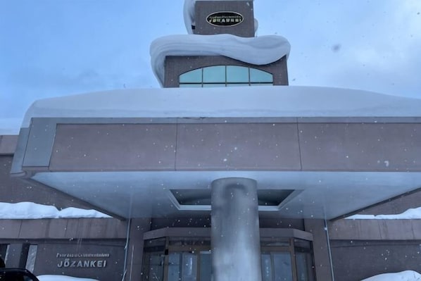 A building with a snow-covered roof and a sign that reads 'Jozankei.'