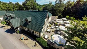 Ein traditionelles Gebäude mit Gründach, Sitzbereich im Freien und einem Parkplatz.