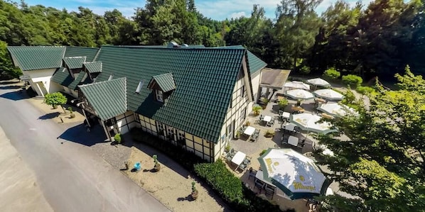 Um edifício tradicional com telhado verde, área de estar ao ar livre e estacionamento.