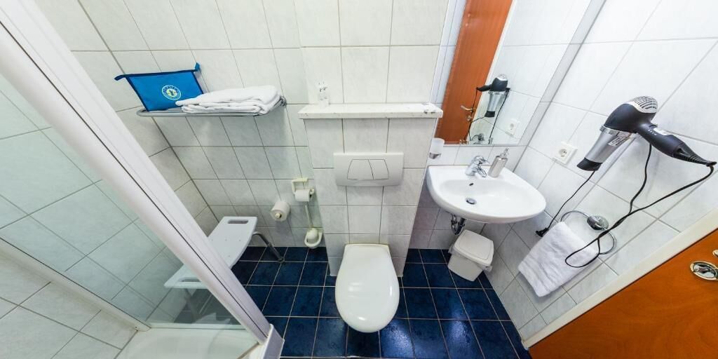 Ein kleines Badezimmer mit Toilette, Waschbecken und Föhn.
