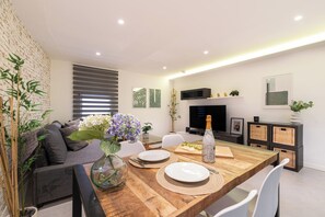 A modern living room with a wooden dining table, a sofa, and a TV. - Spectacular interior loft (Vigo)