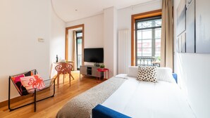 A modern hotel room with a large bed, a TV, a small desk, and a window with curtains. - La Galeria de Principe (Vigo)
