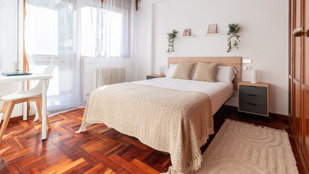 A bedroom with a wooden bed, bedside tables, a desk, and a chair. - Flat Vigo (Vigo)