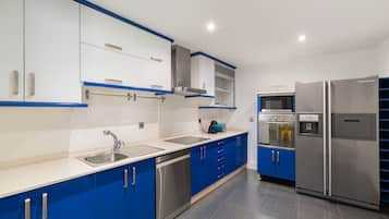 Een koelkast, een magnetron, een oven, kookgerei, borden en bestek