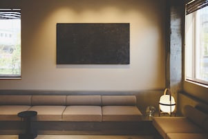 Una sala de estar moderna con un sofá, una mesita y una obra de arte colgada en la pared.