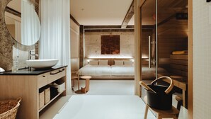 Une salle de bain moderne avec un grand miroir, un lavabo blanc, un meuble-lavabo en bois et une petite table ronde.