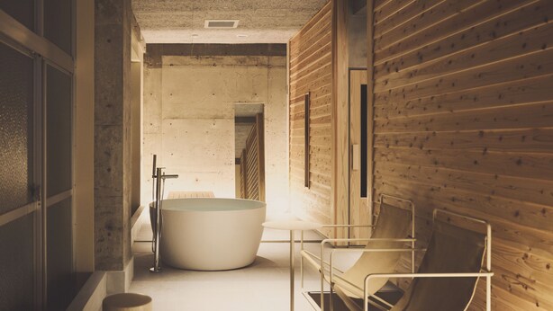 Une salle de bain moderne avec une grande baignoire, un mur en bois et une chaise en métal.