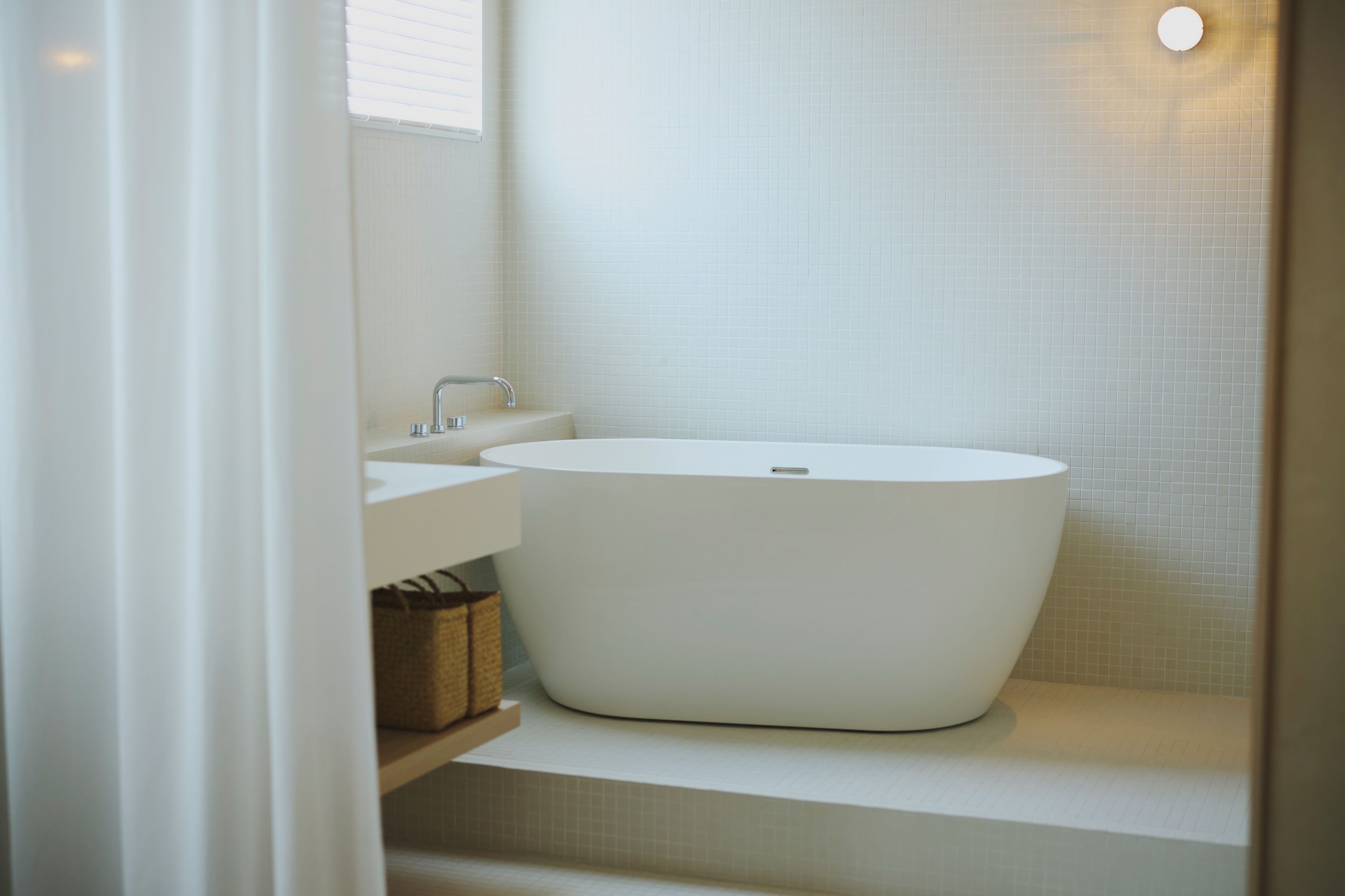 Ein modernes Badezimmer mit einer freistehenden Badewanne, einem Waschbecken und einem Spiegel.