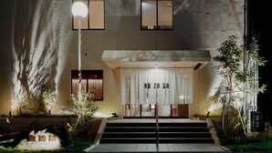 Un bâtiment doté d’une entrée moderne, d’un escalier menant à l’entrée et d’une enseigne indiquant la présence d’un café et d’un bar.