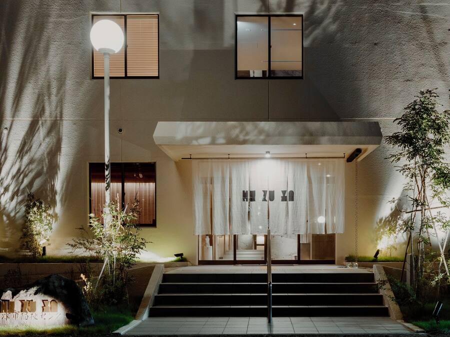 Un bâtiment doté d’une entrée moderne, d’un escalier menant à l’entrée et d’une enseigne indiquant la présence d’un café et d’un bar.