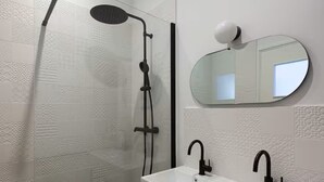 A bathroom with a shower, a sink, and a mirror. - APARTMENT WITH MAGNIFICENT VIEW OF THE OLD PORT (Marseille)