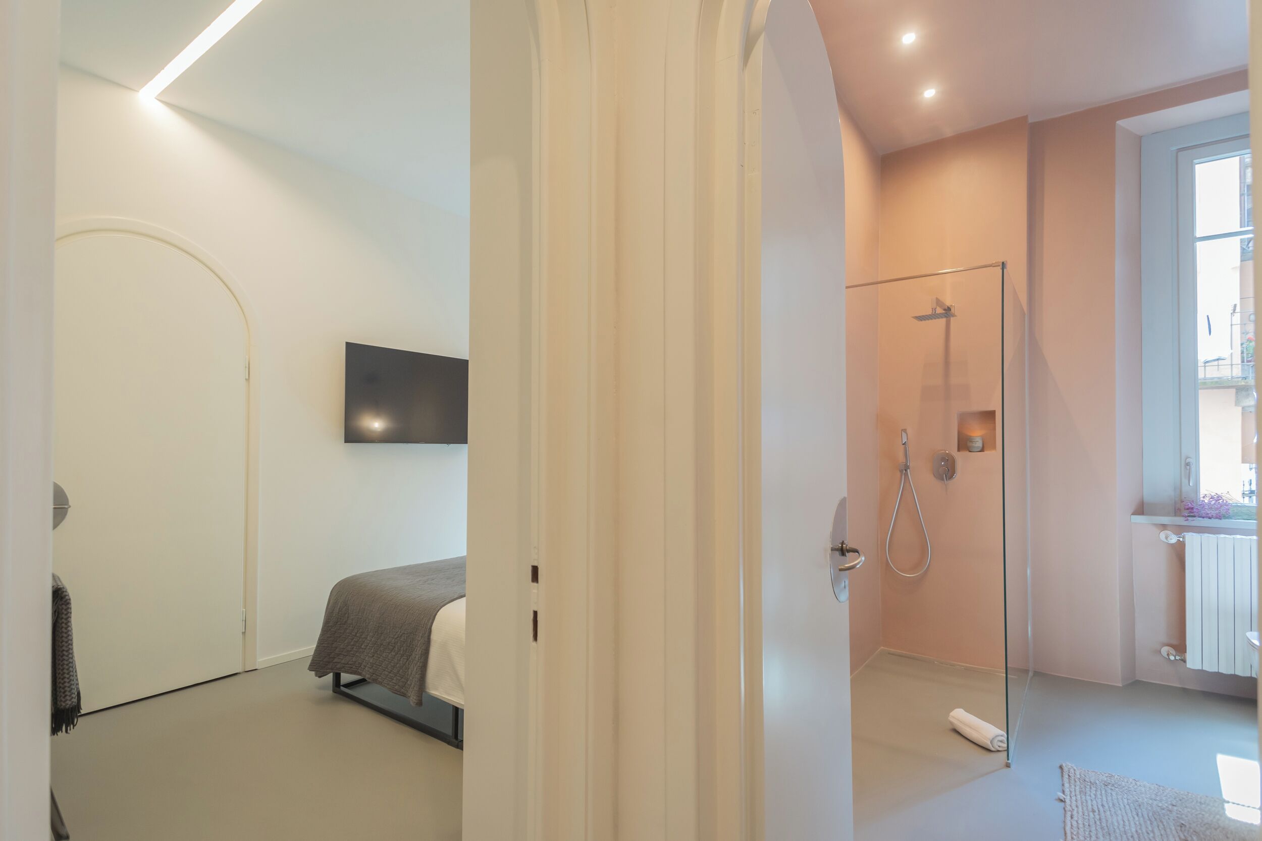 A modern bathroom with a glass shower enclosure, a toilet, and a sink.