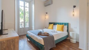 A bedroom with a bed, bedside table, and a window. - Como Liberty Suites - Gatsby by Rent all Como (Como)