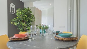 A dining table set with colorful bowls, wine glasses, and a vase. - Como Panorama by Rent all Como (Como)