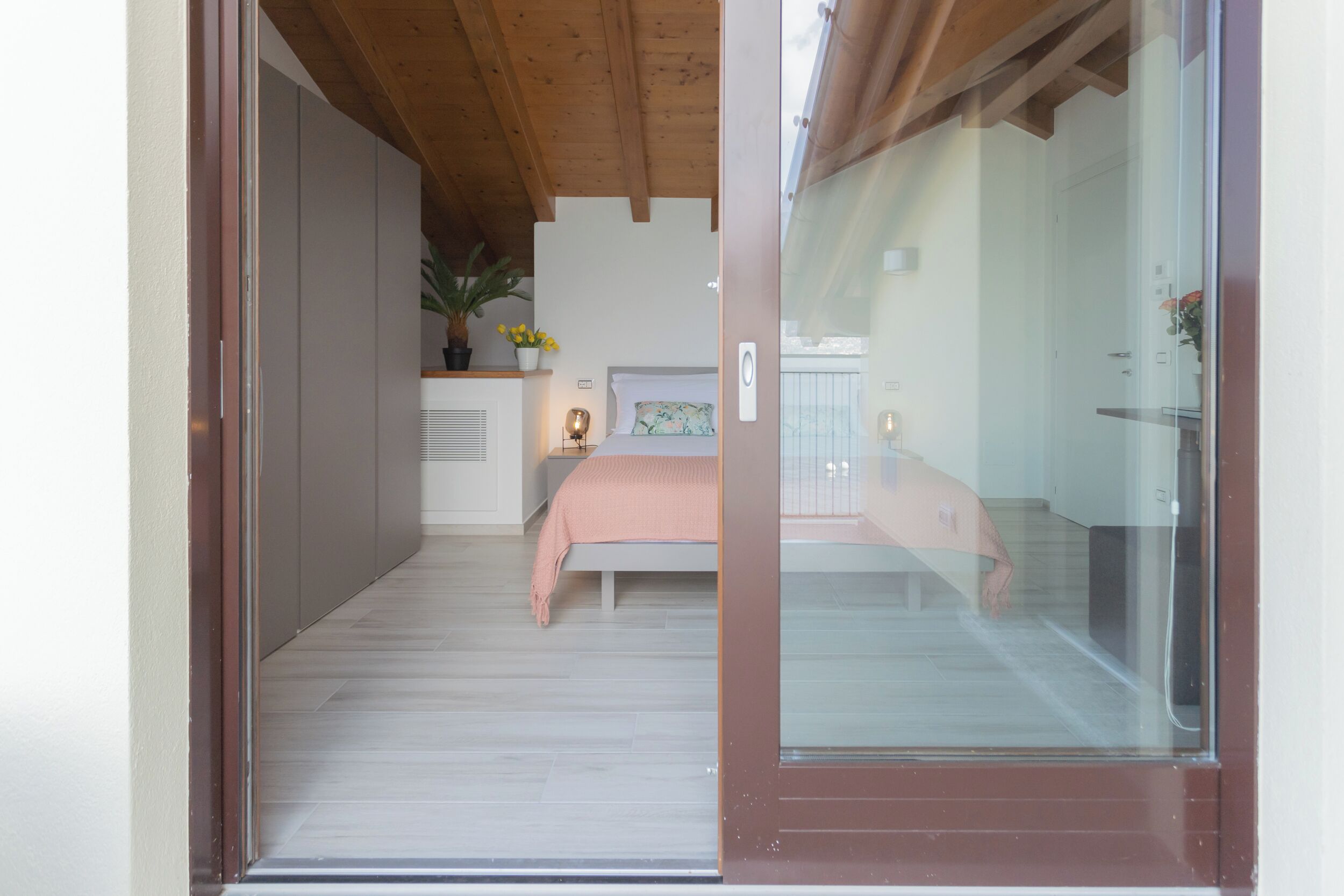 Un dormitorio con cama, mesita de noche y ventana.