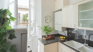 A modern kitchen with white cabinets, a black countertop, a sink, and a clock on the wall. - Filanda - Best Lakefront in Como by Rent all Como (Como)