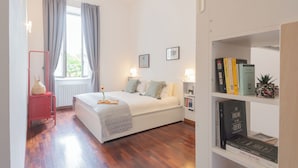 A bedroom with a bed, bedside lamps, a bookshelf, and a window with curtains. - Filanda - Best Lakefront in Como by Rent all Como (Como)